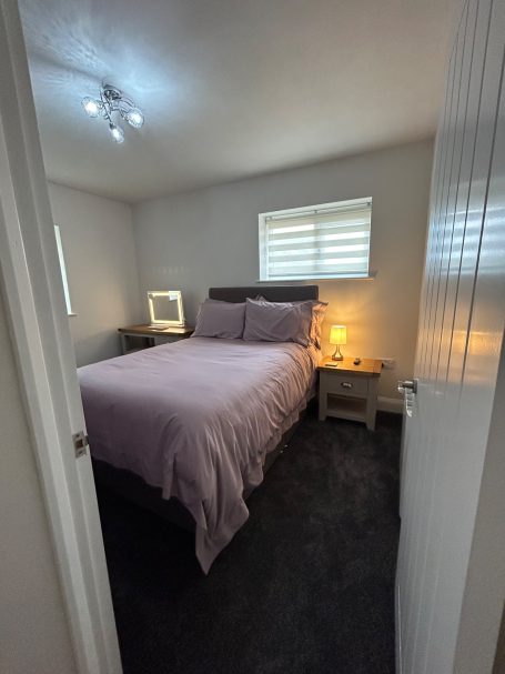 Cozy bedroom with a double bed, soft lighting, and a minimalist decor.